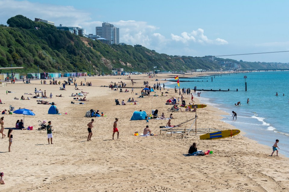 People basking in the sunny weather on Bournemouth Beach in Dorset today