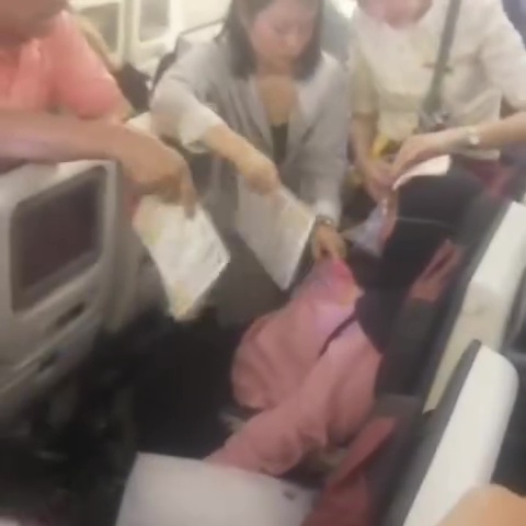 One passenger being fanned by others trying to cool her down
