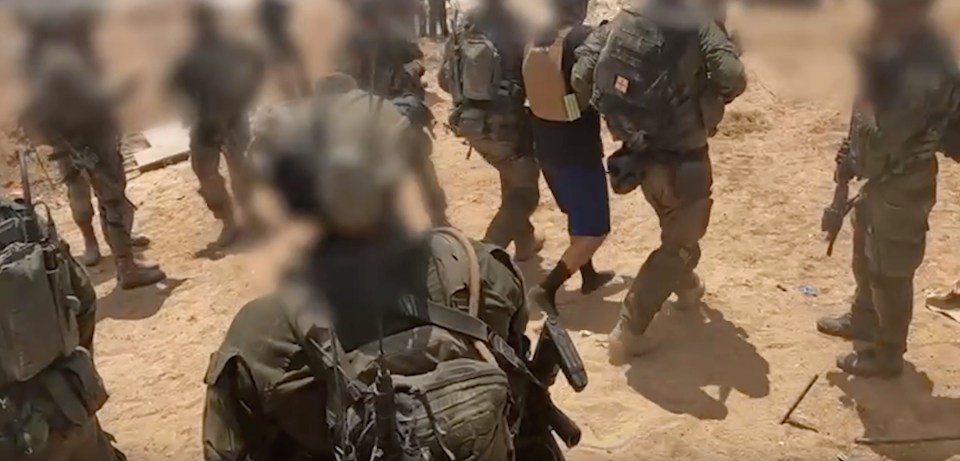 A freed hostage is led away by IDF forces to a waiting helicopter