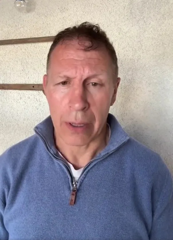 a man wearing a blue sweater has a zipper on the front