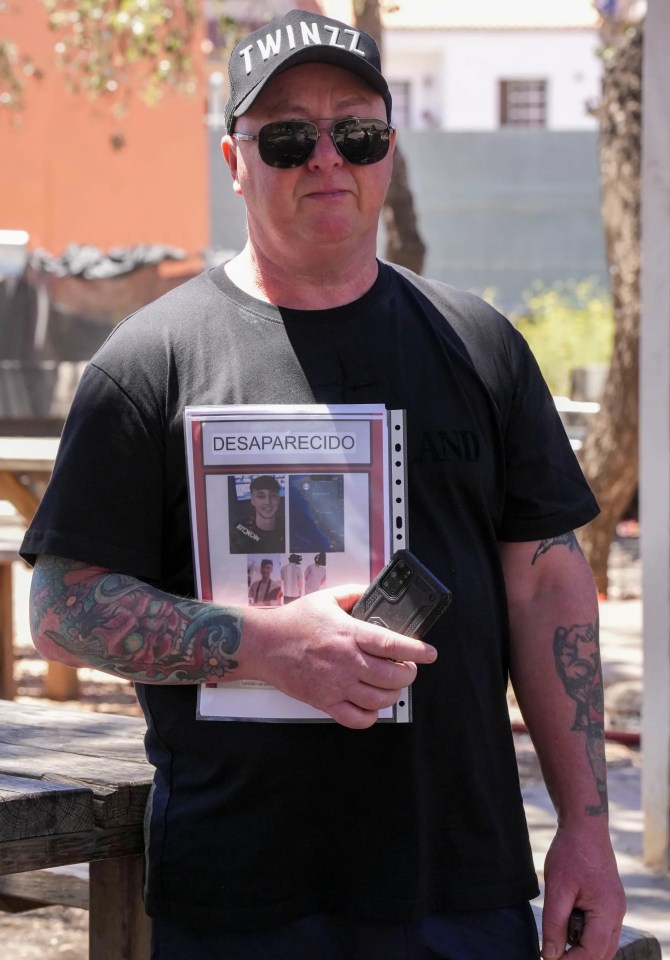 a man wearing a black shirt that says twinzz on it