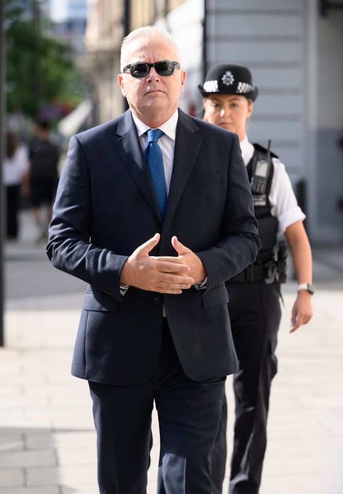 a man in a suit and tie is walking with a police officer