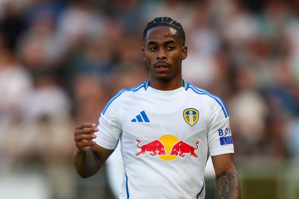 a soccer player wearing a white shirt with a red bull on it