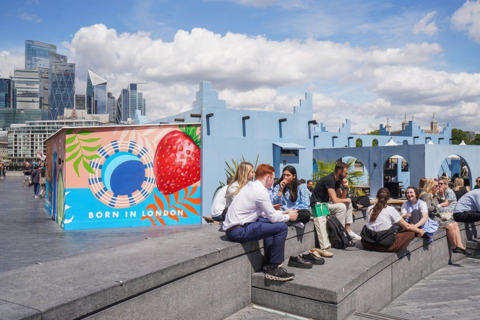City workers are seen relaxing in the warm summer sunshine in London yesterday
