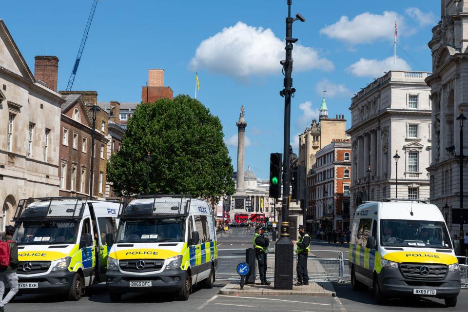 a row of police vans are parked on the street