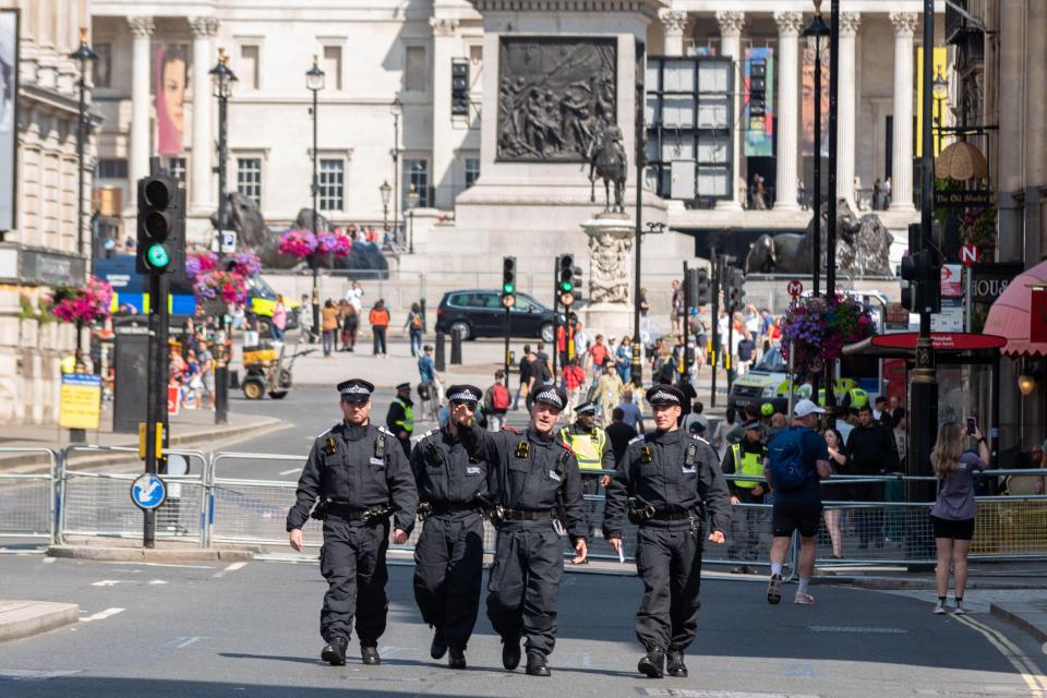 a group of police officers are walking down a street