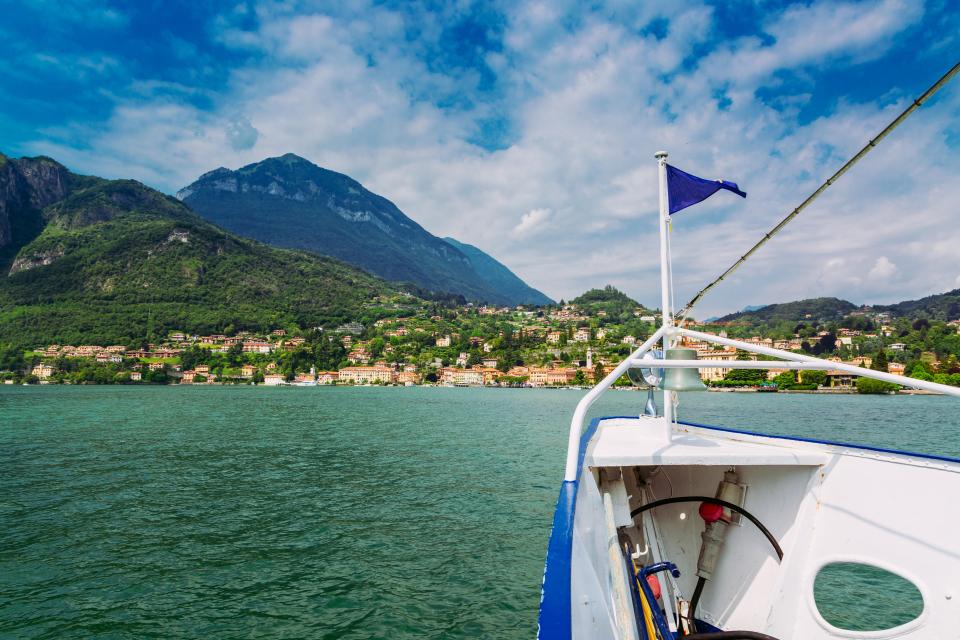 a few boats are docked in the water near a stone wall