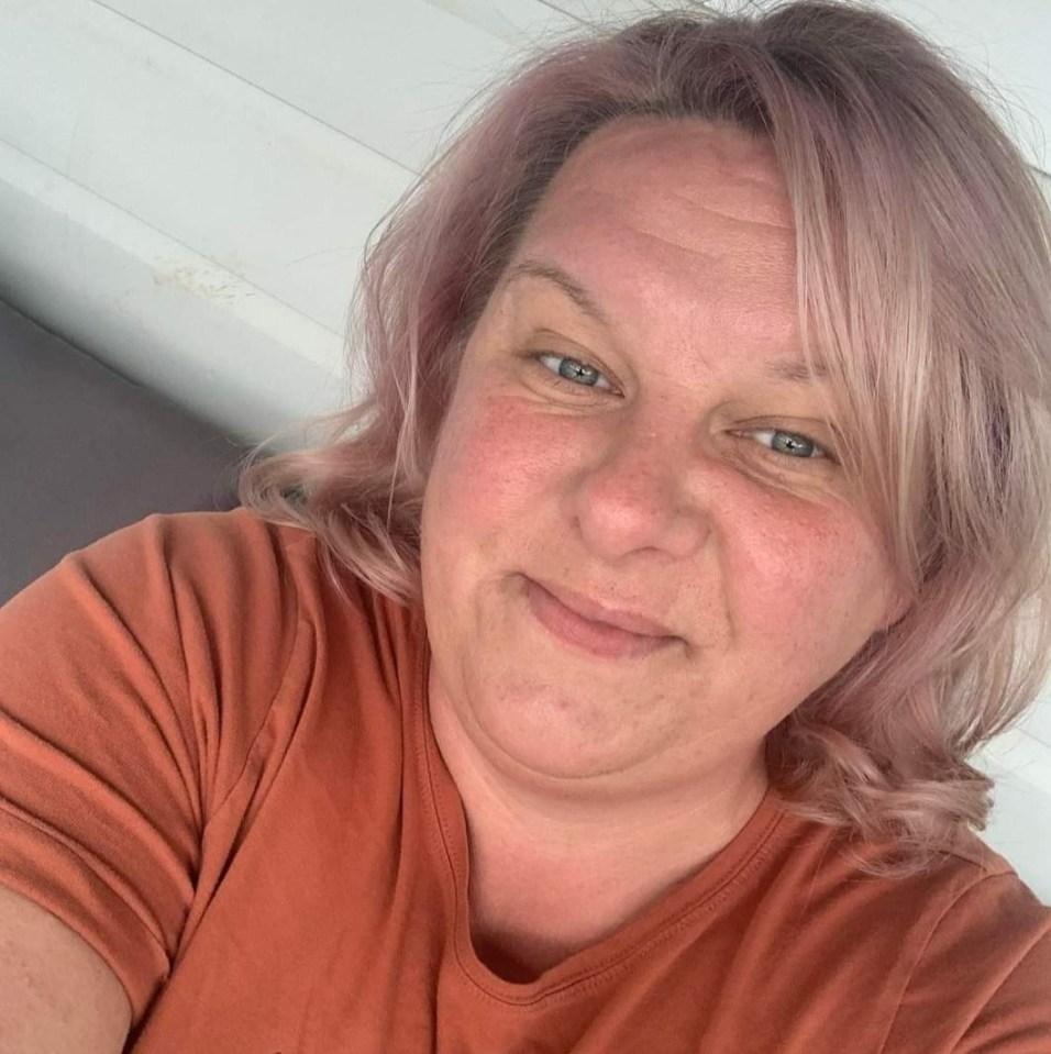 a woman with pink hair is smiling for the camera