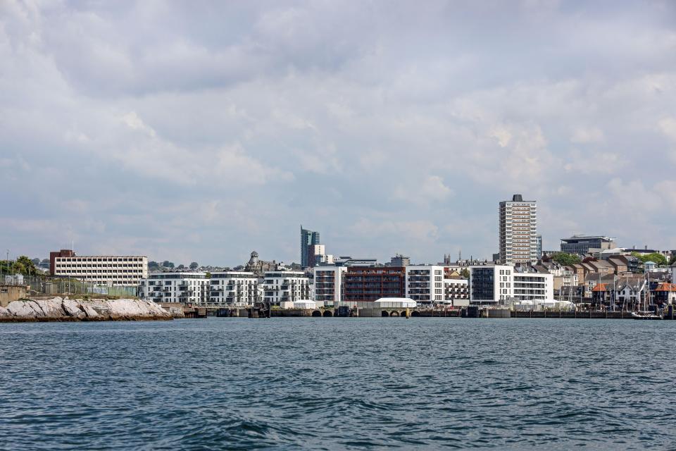 a row of buildings on a cliff overlooking a body of water
