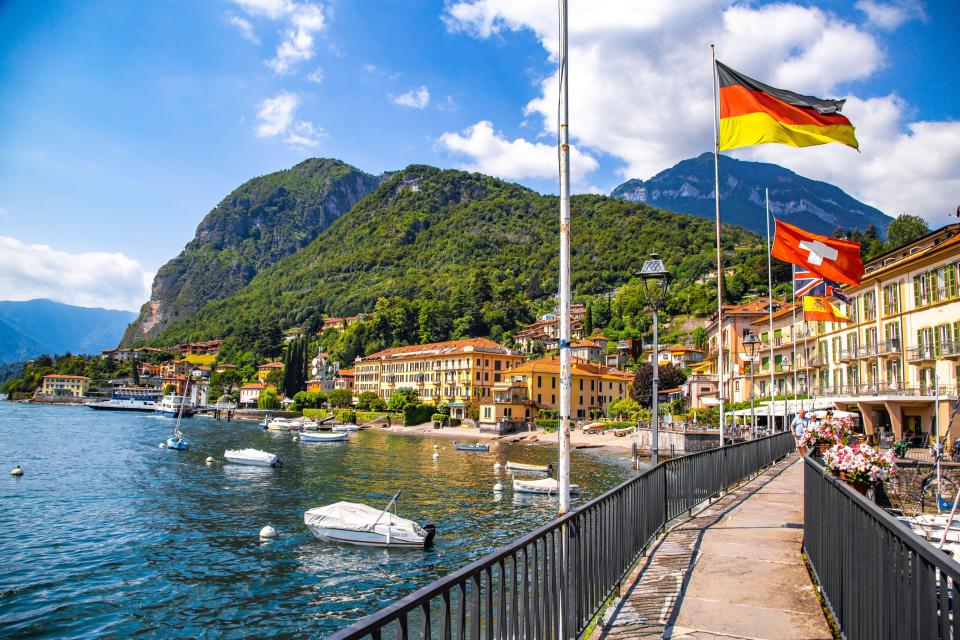 a lake with a mountain in the background and houses on the shore