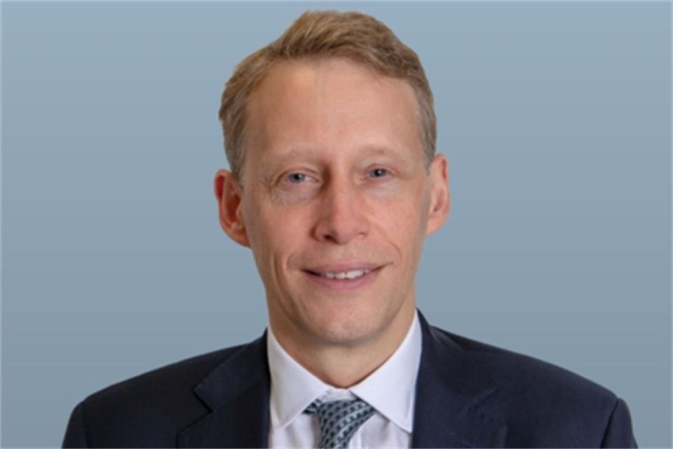 a man in a suit and tie smiles for the camera