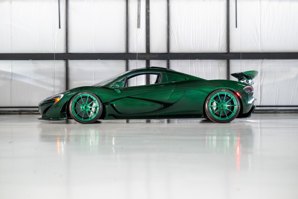 a green sports car is parked in a garage
