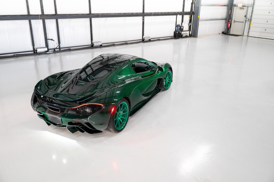 a green sports car is parked in a garage