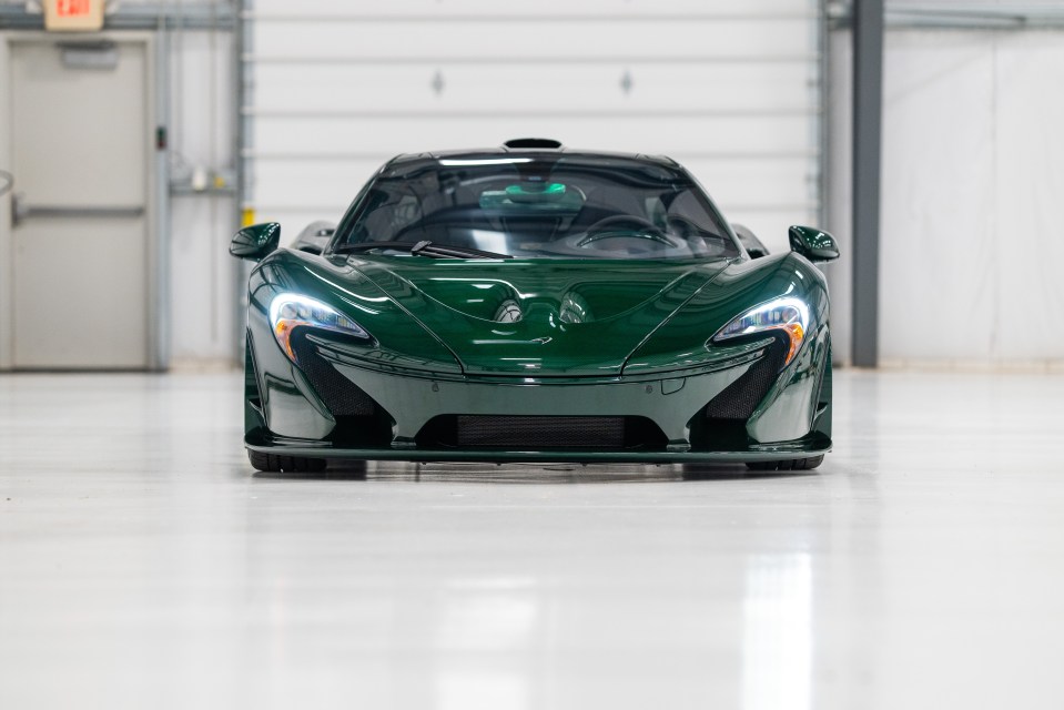 a green sports car is parked in a garage
