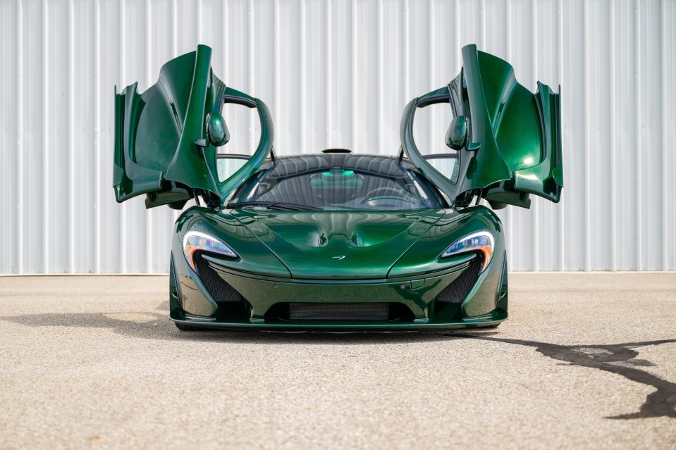 a green mclaren sports car with its doors open