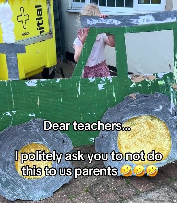 The little girl struggled with her giant cardboard tractor as she headed home from school