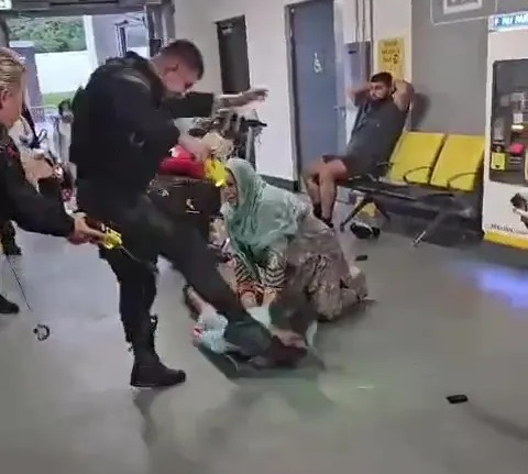 a group of people are sitting in a waiting room at an airport .