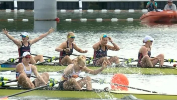 a group of women are rowing a boat in the water