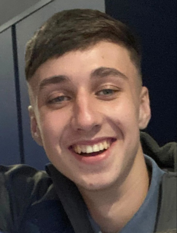 a young man in a blue shirt smiles for the camera