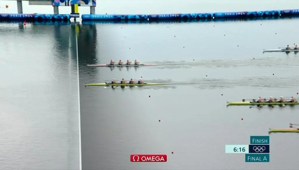 a row of boats are in the water and the omega logo can be seen