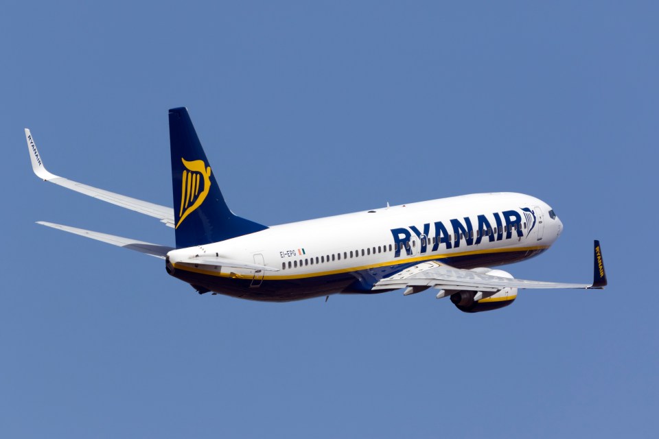 a ryanair plane is flying through a clear blue sky