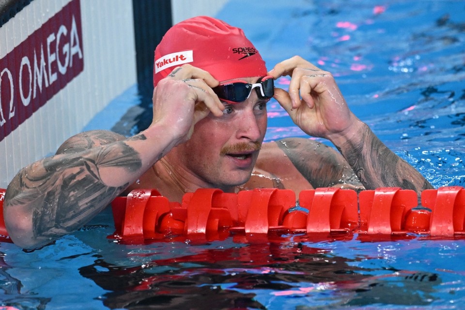 a man in a swimming pool wearing a red speedo hat