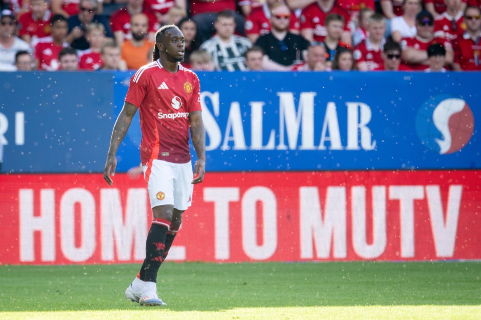 a soccer player stands in front of a sign that says home to mutv