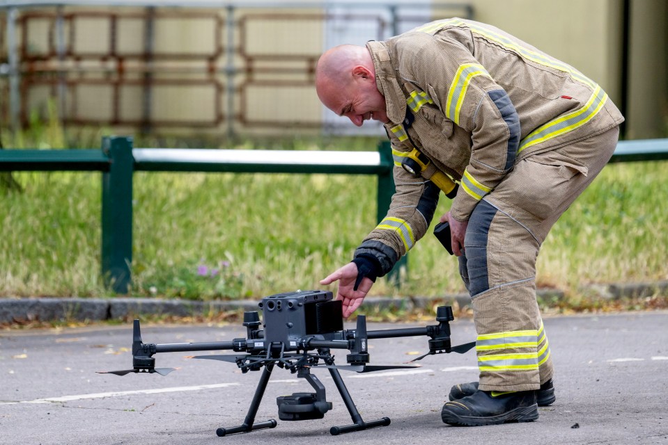 a man in a fireman 's uniform is working on a drone
