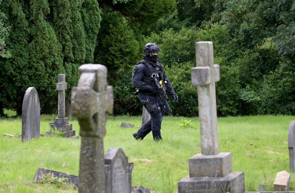 a soldier walking through a cemetery with crosses and graves