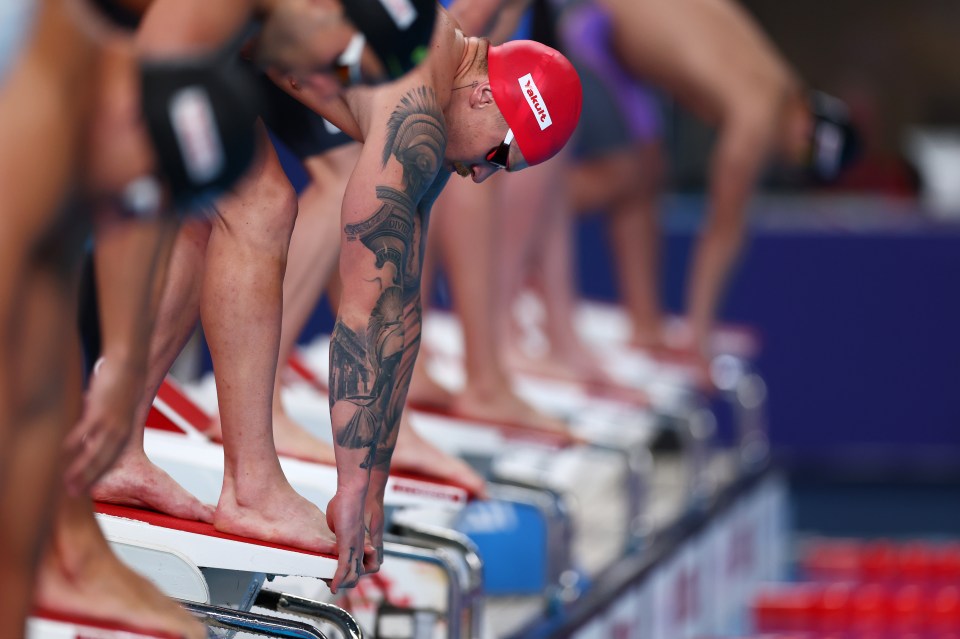 a man with a tattoo on his arm is getting ready to swim