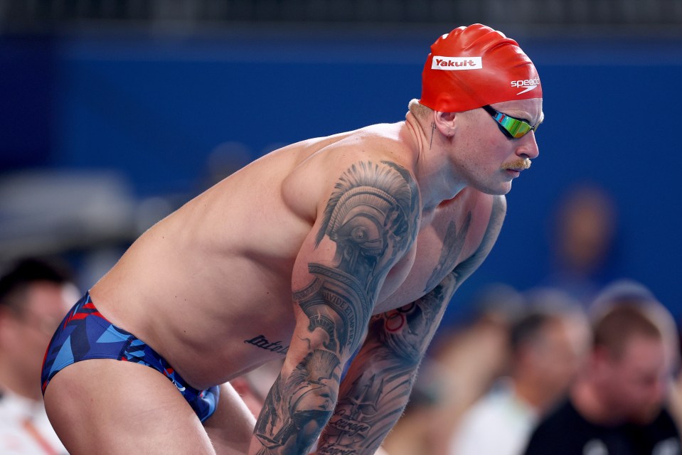 a man wearing a red speedo swim cap is getting ready to swim