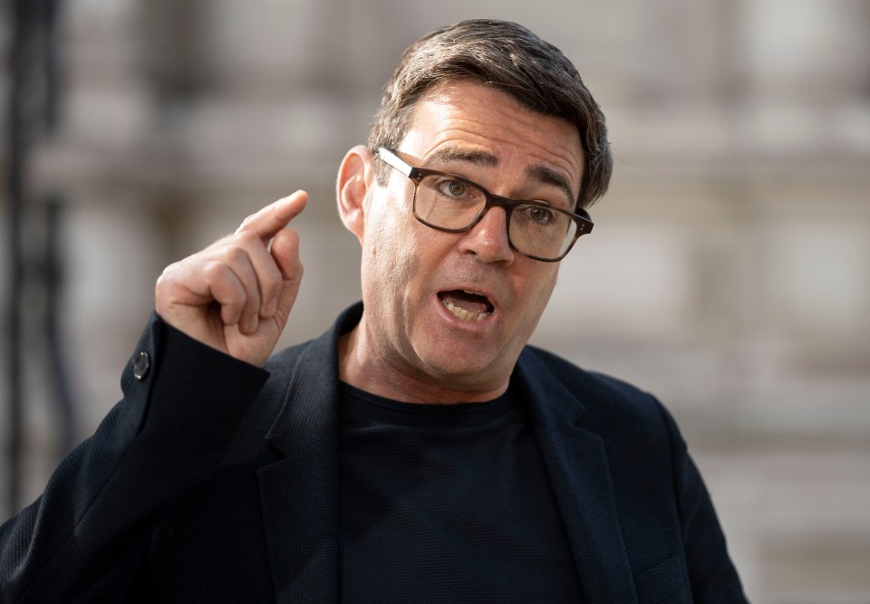 a man wearing glasses and a black jacket points his finger