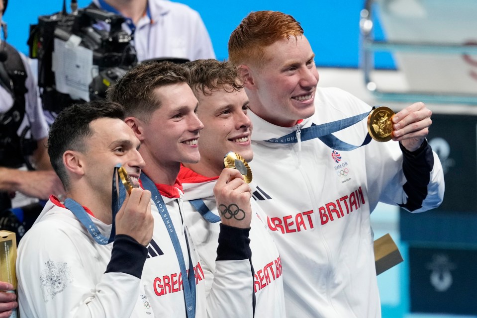 four athletes from great britain hold up their gold medals