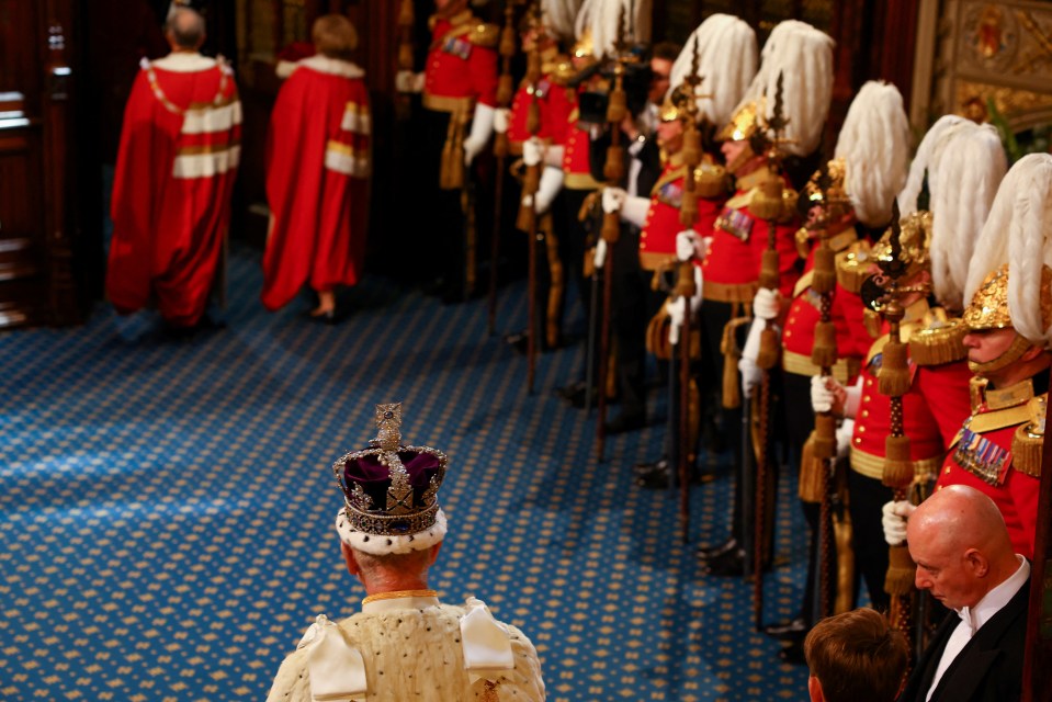 a man in a crown stands in front of a line of soldiers