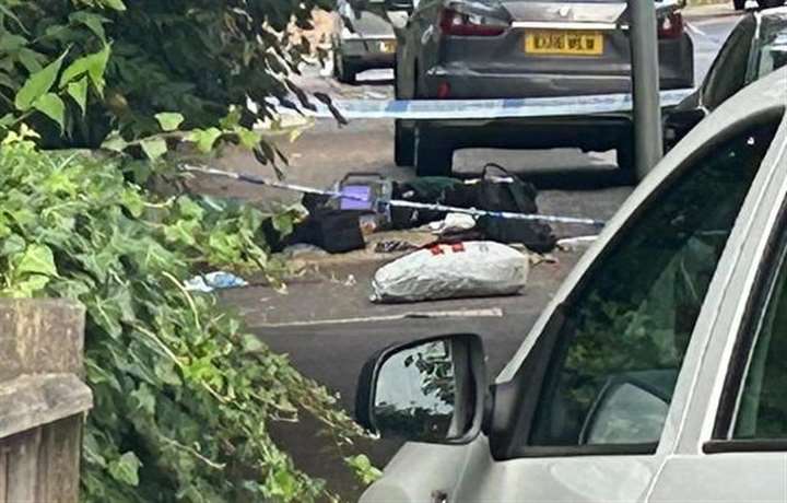 a white van is parked on the side of the road next to a police tape .