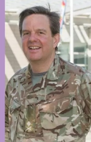 a man in a military uniform is smiling for the camera