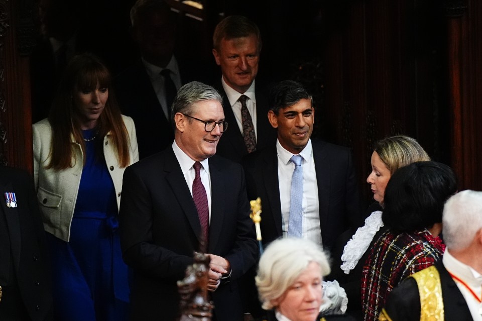 a man in a suit and tie stands in a crowd of people