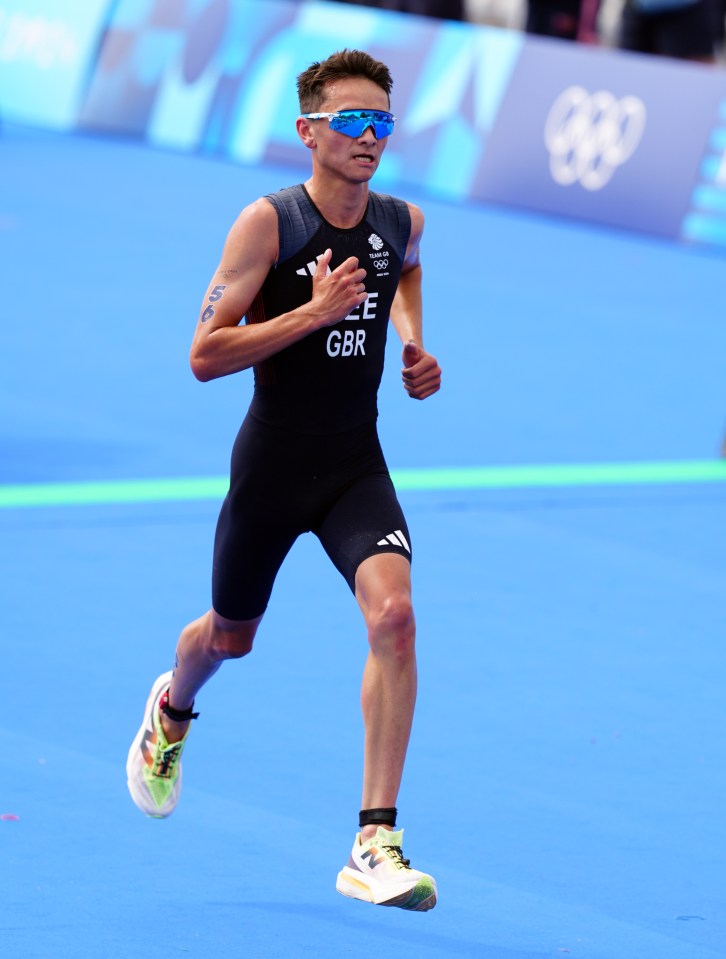 a runner wearing a gbr shirt is running on a blue surface