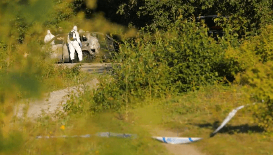 a man in a white suit is standing next to a car