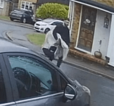 a man is walking down the street next to a car .