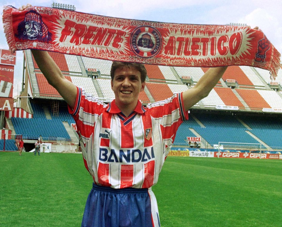a man in a bandai jersey holds up a scarf