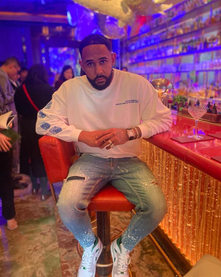 a man sits on a bar stool wearing a white sweatshirt that says " i 'm not a hipster "