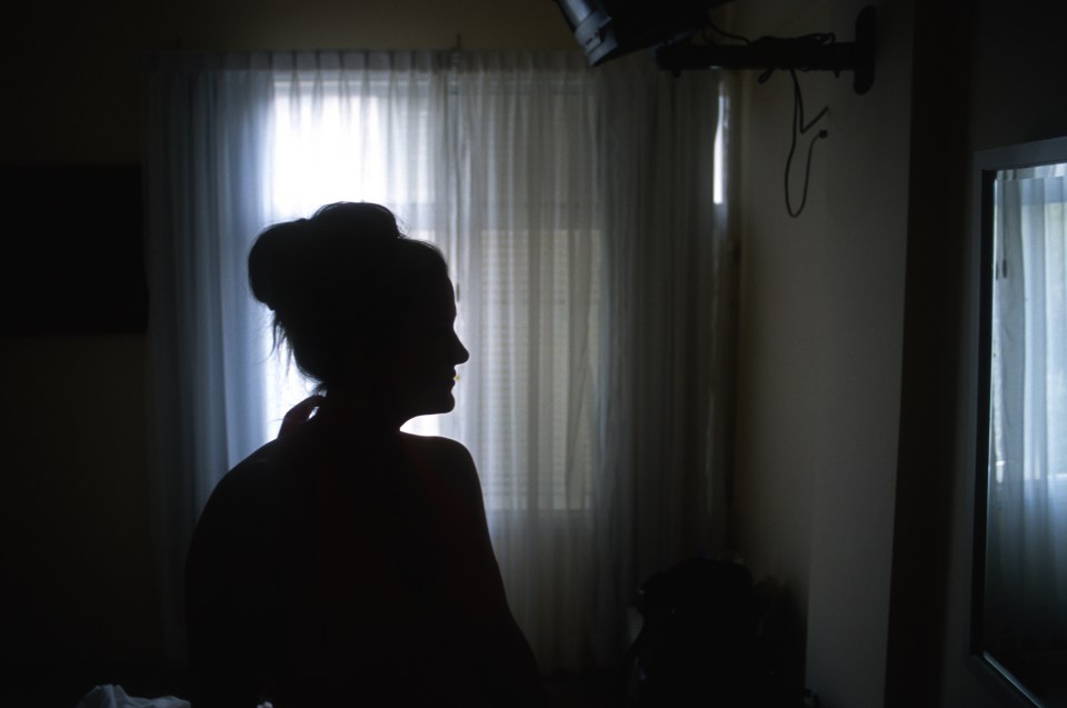 a silhouette of a woman standing in front of a window