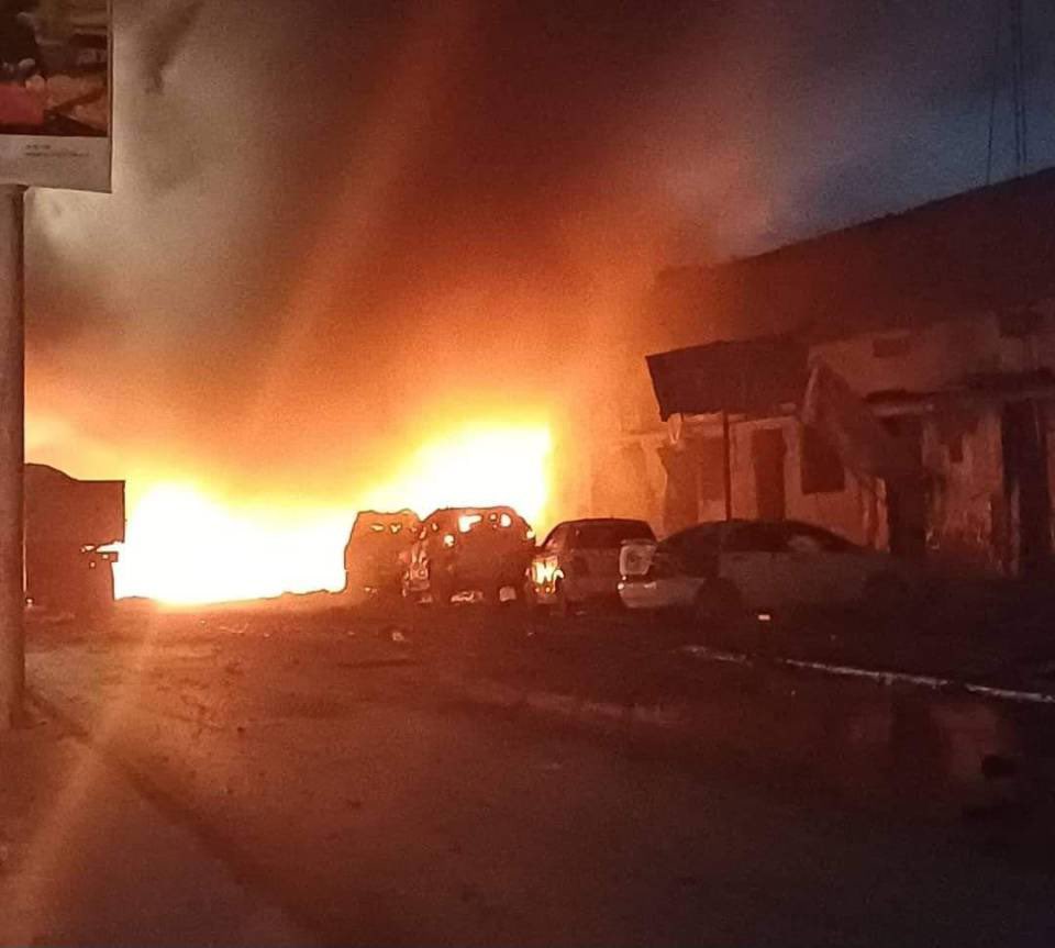 several cars are parked in front of a large fire
