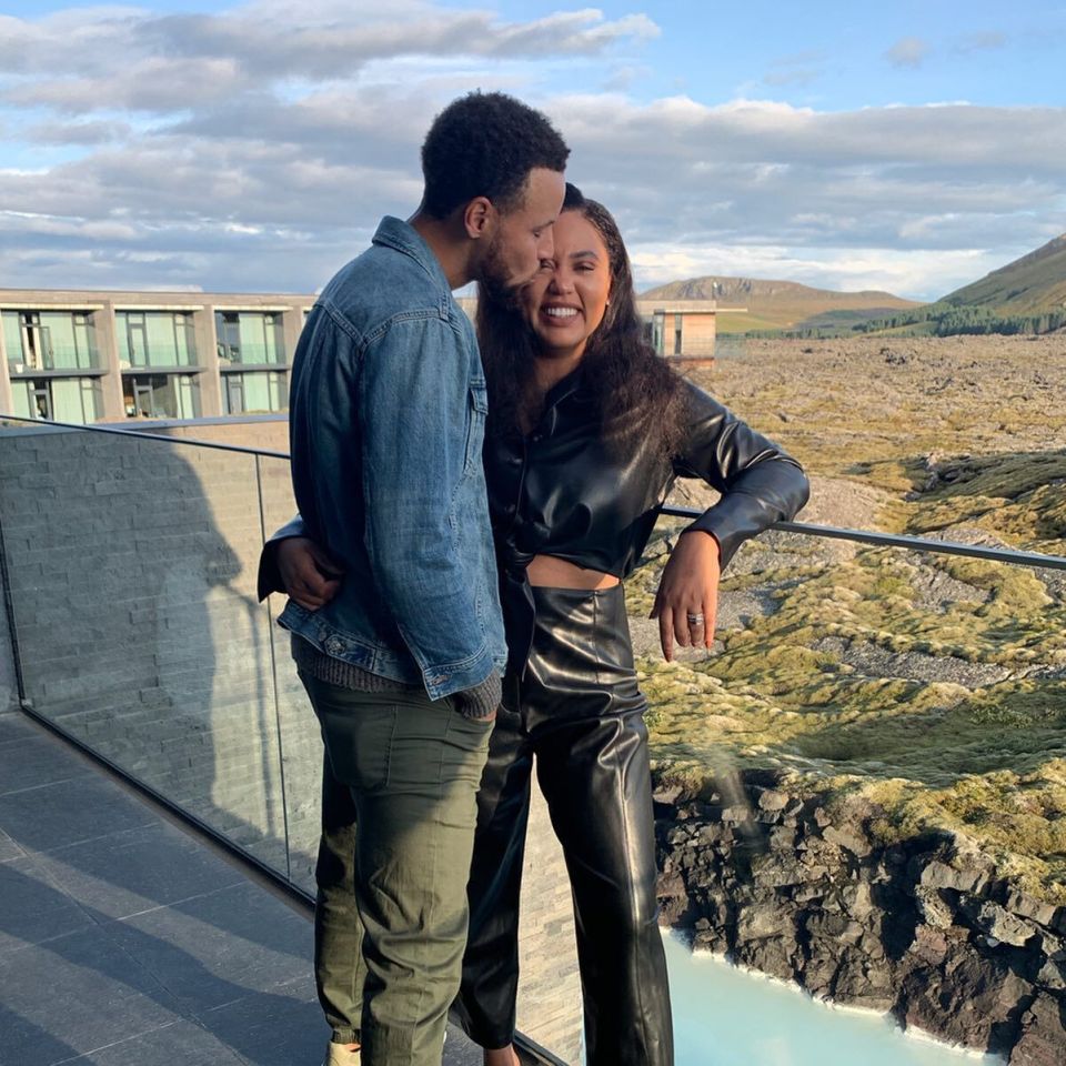 a man in a denim jacket kisses a woman on the forehead