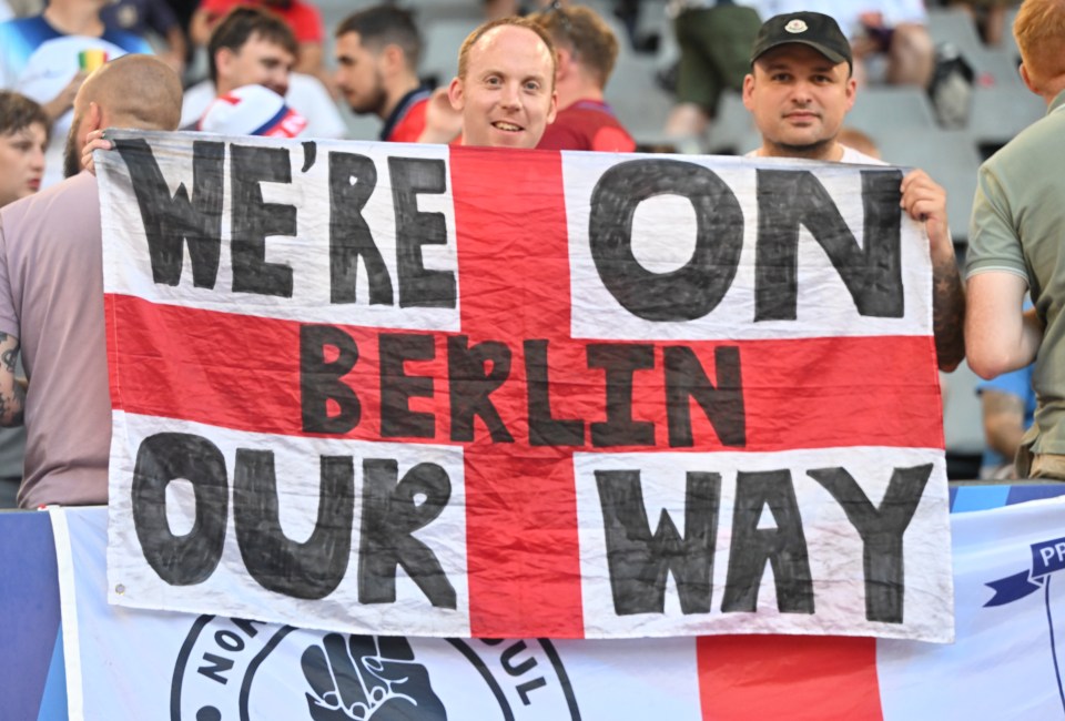 a man holds up a sign that says we 're on berlin our way
