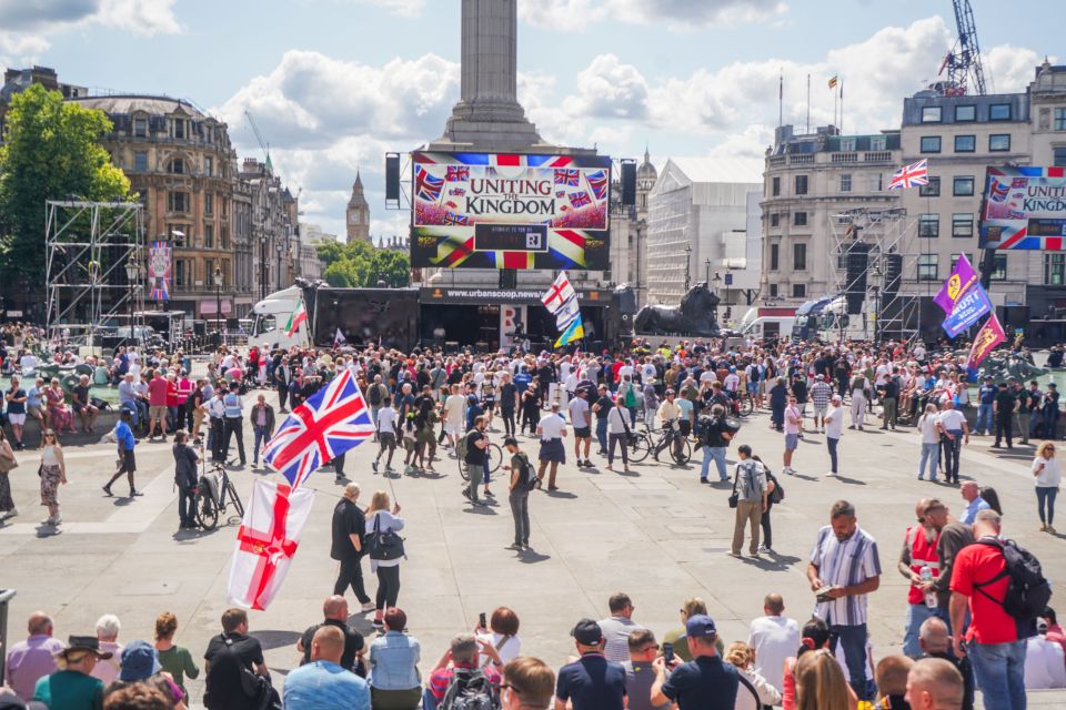 a large crowd of people are gathered in front of a sign that says united kingdom