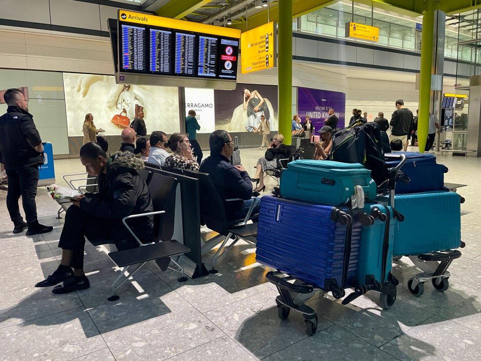 people are waiting at an airport under a sign that says arrivals
