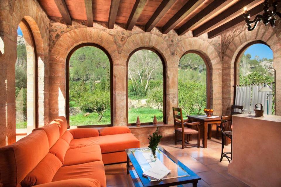 a living room with arched windows and an orange couch