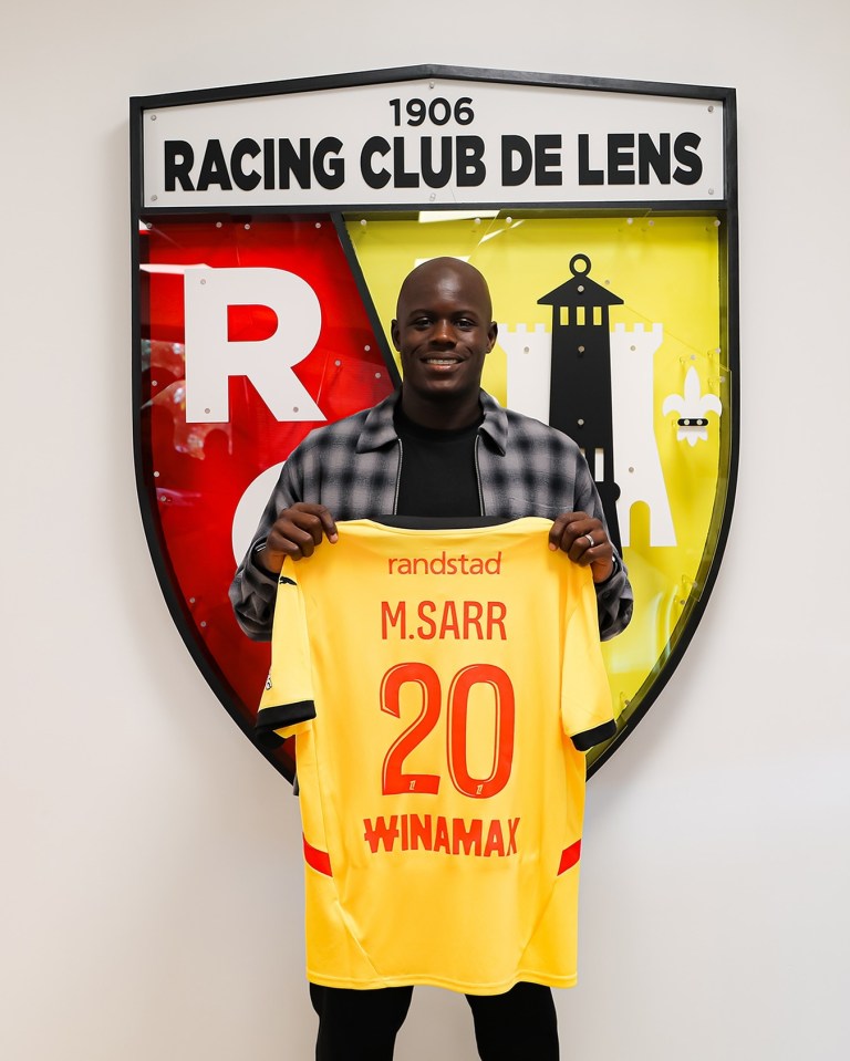 a man holding a yellow jersey with the number 20 on it